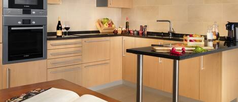 Una cocina moderna con electrodomésticos de acero inoxidable, armarios de madera y una isla central con fregadero.
