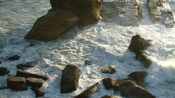 Una costa rocosa con olas rompiendo sobre la orilla.
