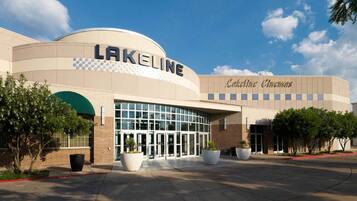 Un bâtiment de cinéma à la façade incurvée, doté d’une grande entrée en verre et d’une enseigne indiquant « Lakeline ».