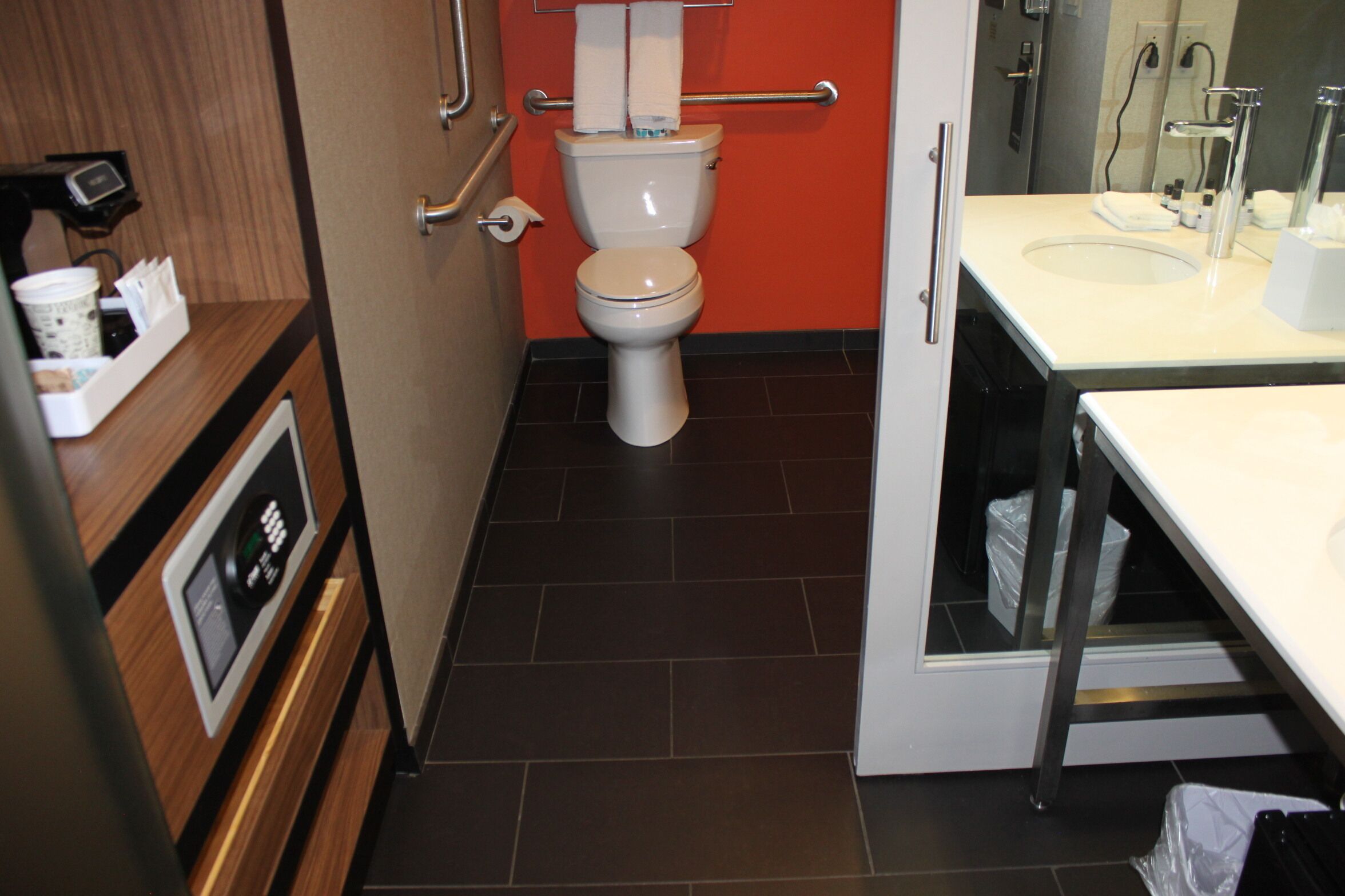 A modern bathroom with a toilet, sink, and a mirror.