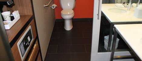 A modern bathroom with a toilet, sink, and a mirror.
