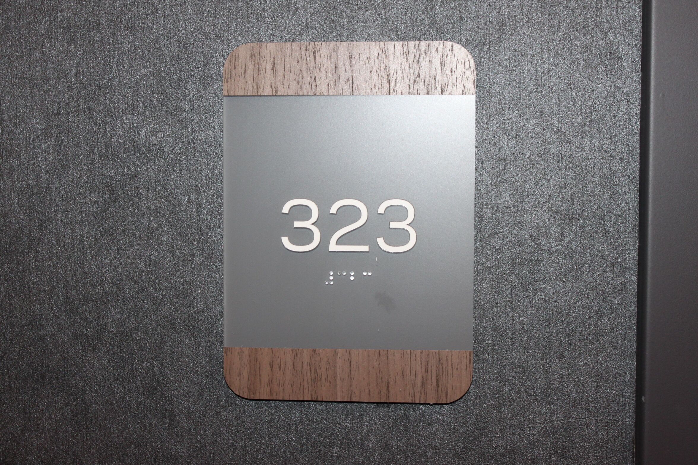 Placa de número de quarto com o número 323.