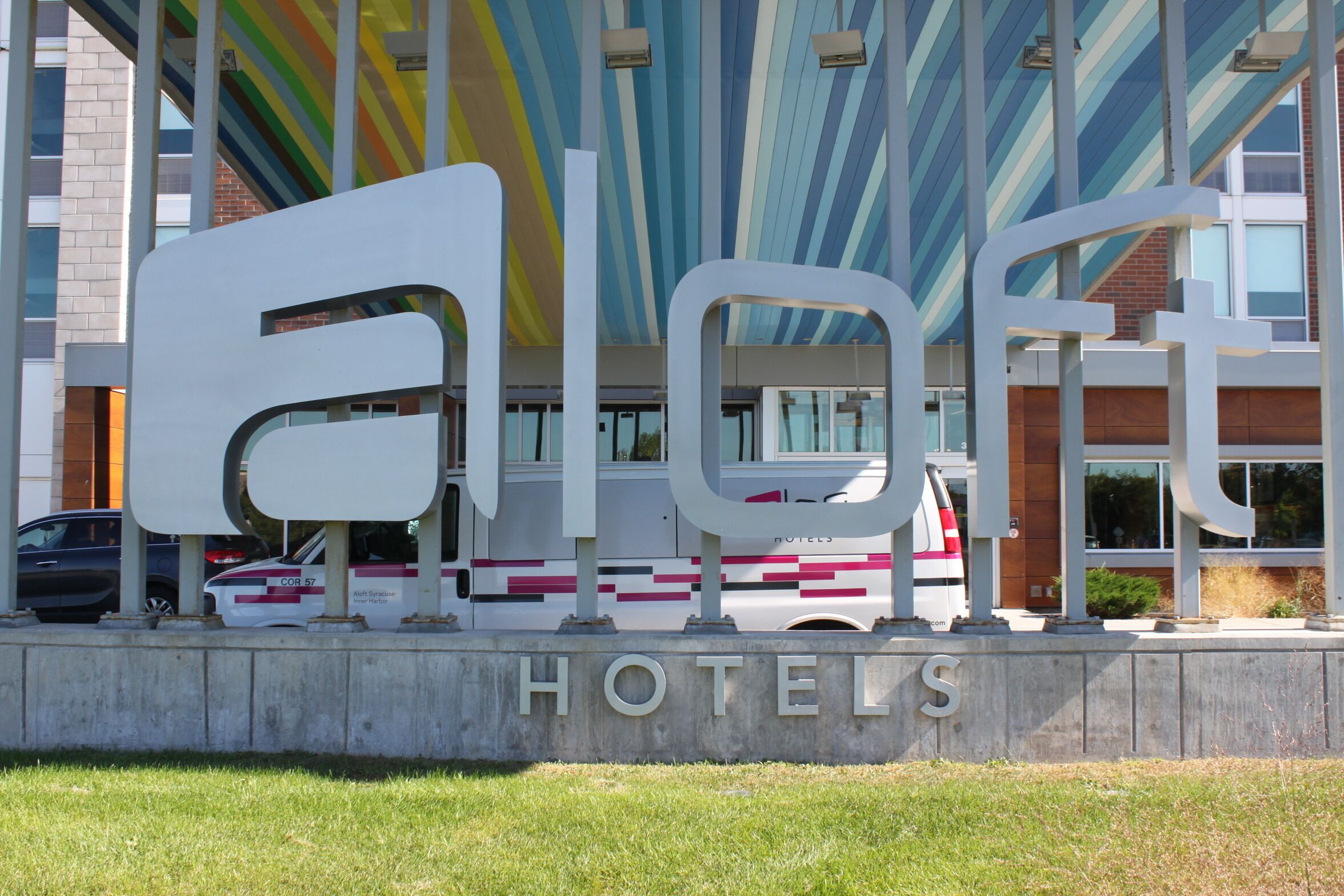 A hotel sign with the name 'Eloft Hotels' and a modern building in the background.