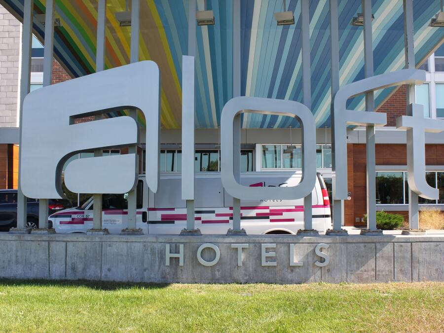 A hotel sign with the name 'Eloft Hotels' and a modern building in the background.