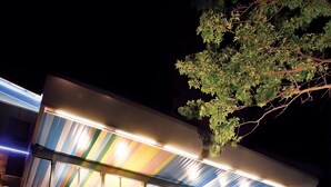 Un hôtel moderne doté d’une grande enseigne lumineuse sur laquelle on peut lire « aod W HOTELS » et d’une façade en verre.