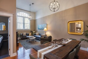 A spacious living area with a dining table, sofas, and a large window. - 3rd Street Flats (McMinnville)