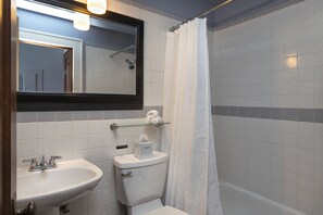 Een badkamer met wastafel, toilet en douchegordijn.