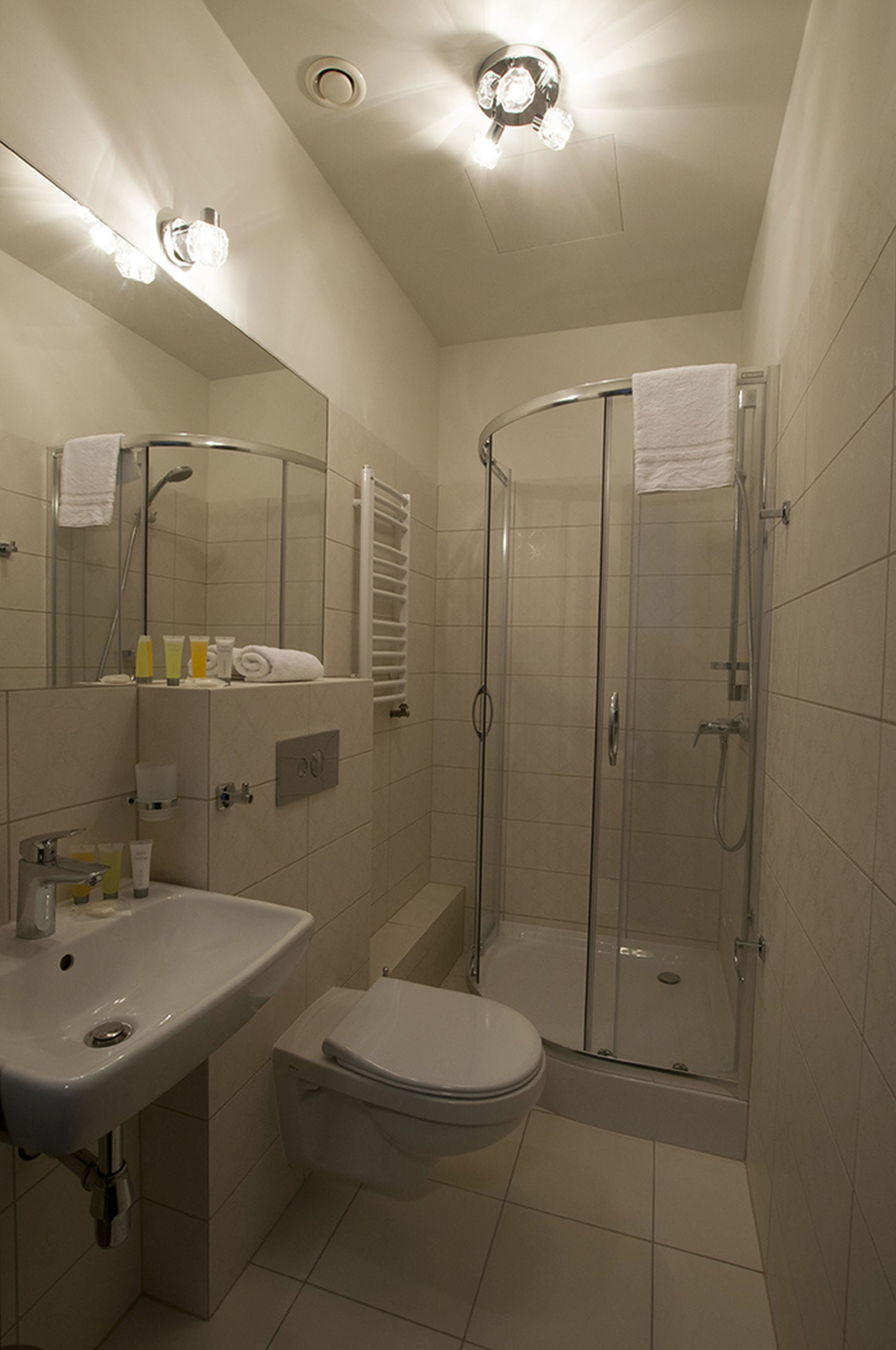Un baño con lavabo, inodoro y ducha con mampara de vidrio.
