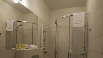 A bathroom with a sink, toilet, and glass-enclosed shower.