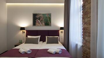 A double bed with two pillows, a headboard, and a painting above it.