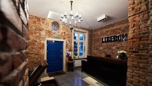 A reception area with a blue door, a chandelier, and a sign that reads "LIBERUM". - Liberum Residence (Gdansk)