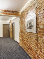 A hallway with a brick wall and a framed picture.