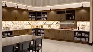 A modern kitchen with wooden cabinets, a dining table, and chairs. There are overhead lights and a patterned backsplash.