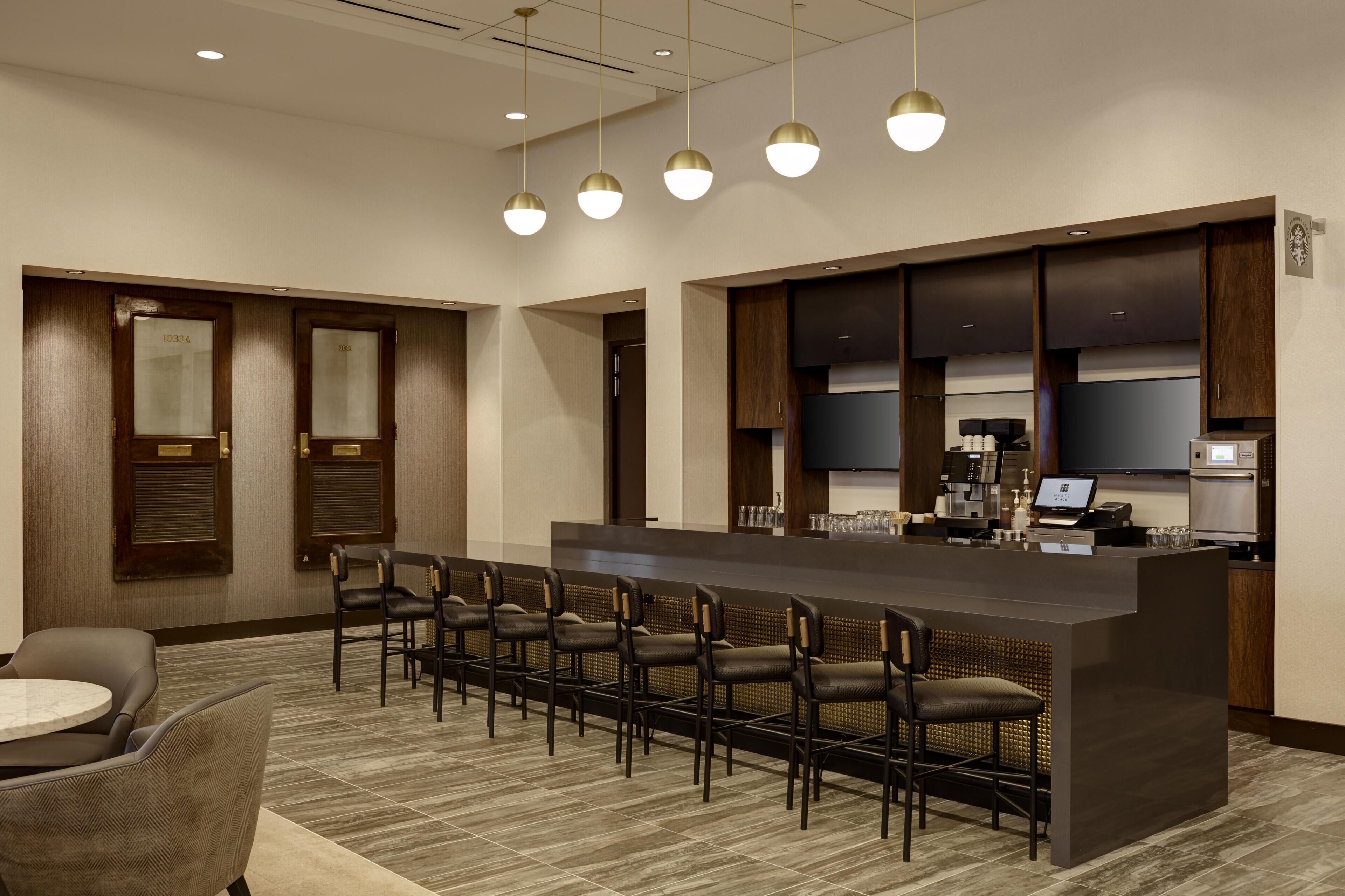 A hotel lobby with a reception desk, seating area, and a minibar.