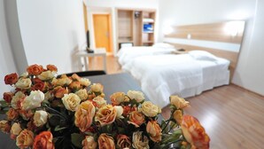 A hotel room with a bed, bedside table, and a TV. - Turis Hotel (Passo Fundo)