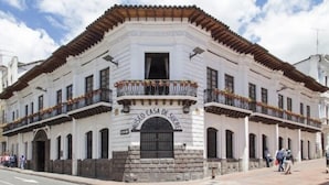 A historic building with a white facade, arched windows, and a balcony with wrought iron railings. - Hotel Casa Montero (Quito)