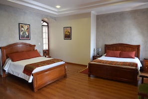 Two wooden beds with matching headboards and footboards, white bedding, and red pillows. - Hotel Casa Montero (Quito)