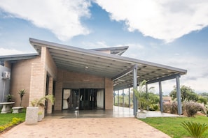 A modern building with a covered entrance, brick walls, and a paved driveway. - HoyoHoyo Acorns Lodge (Hoedspruit)