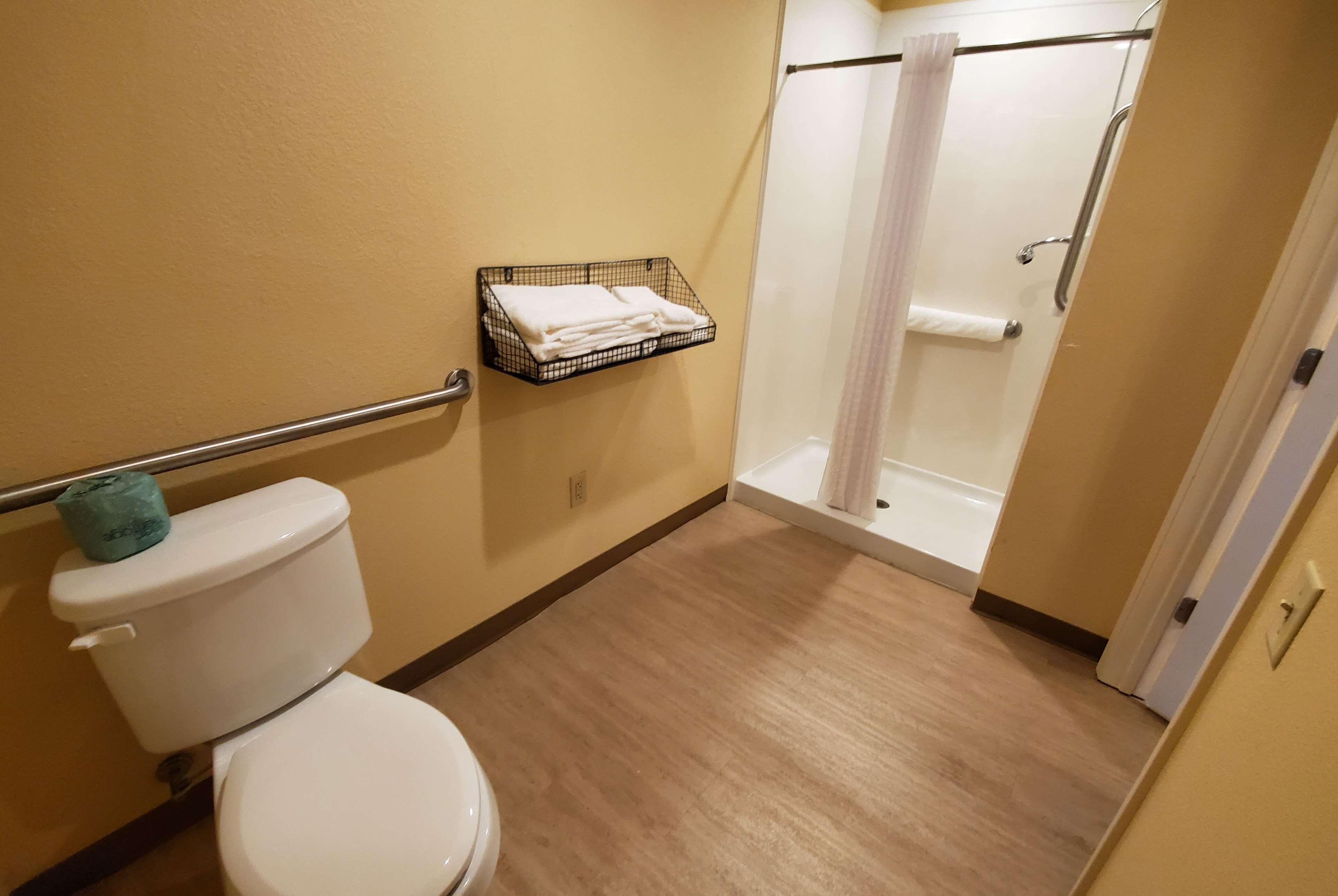 Une salle de bain équipée de toilettes, d’une douche et d’un porte-serviettes.