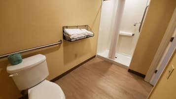 Une salle de bain équipée de toilettes, d’une douche et d’un porte-serviettes.