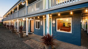 A two-story building with a balcony, potted plants, and a sign for 'Sand Dollar Inn & Cottages'. - Sand Dollar Condos (Pacific Beach)