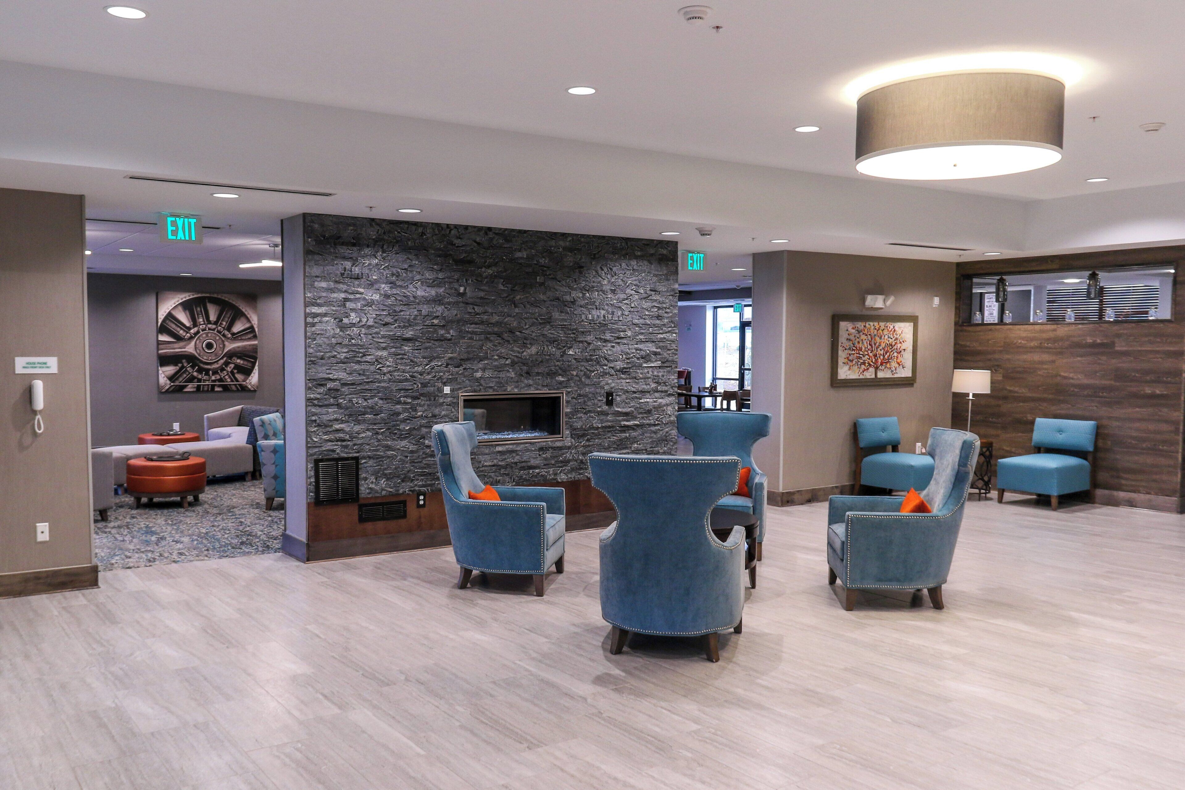 A lobby area with seating, a stone wall, and exit signs.