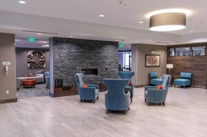 A lobby area with seating, a stone wall, and exit signs.