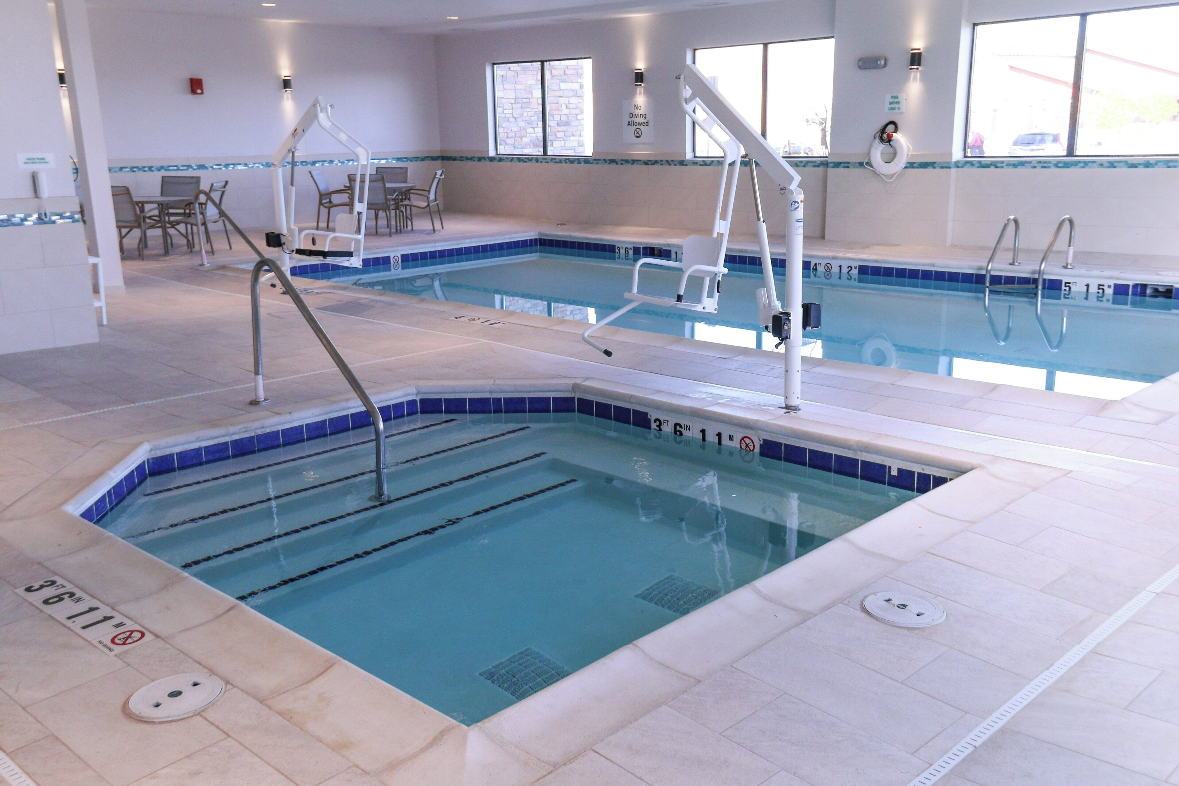 Ein Hotelpool mit mehreren Bahnen, Sprungbrettern und Liegestühlen.