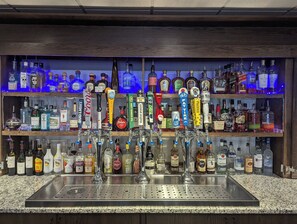 A bar with multiple liquor dispensers and a variety of bottles in the background. - Holiday Inn & Suites Denver Tech Center-Centennial by IHG (Centennial)