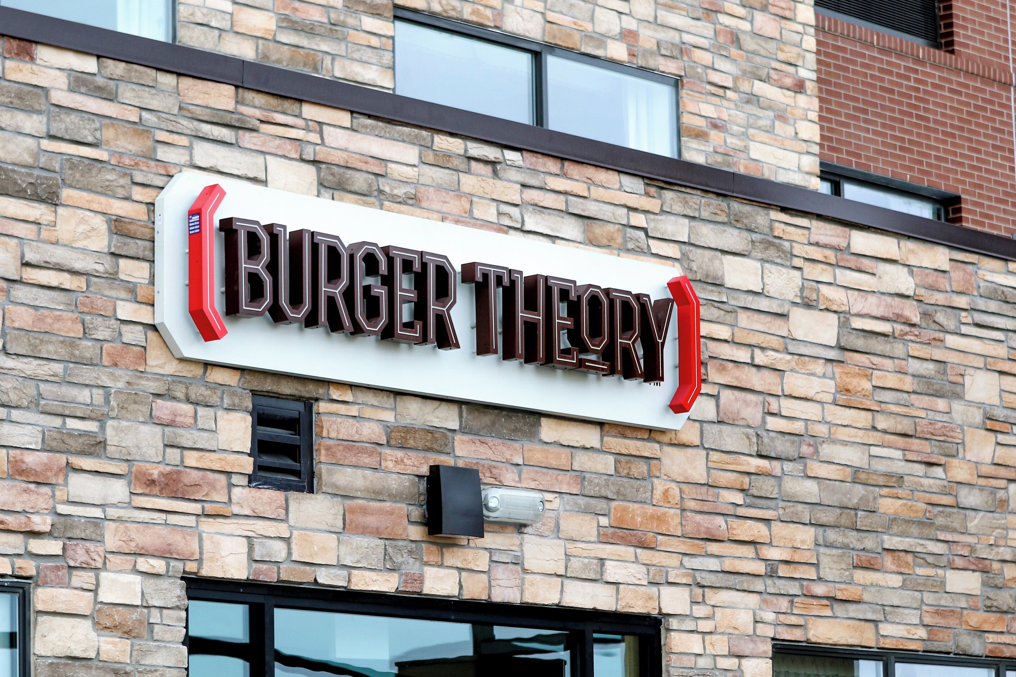 A brick building with a sign that reads 'BURGER THEORY'.