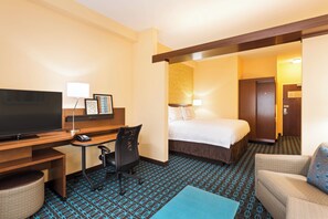 A hotel room with a bed, a desk with a computer, a television, and a sofa. - Fairfield Inn & Suites by Marriott Johnson City (Johnson City)