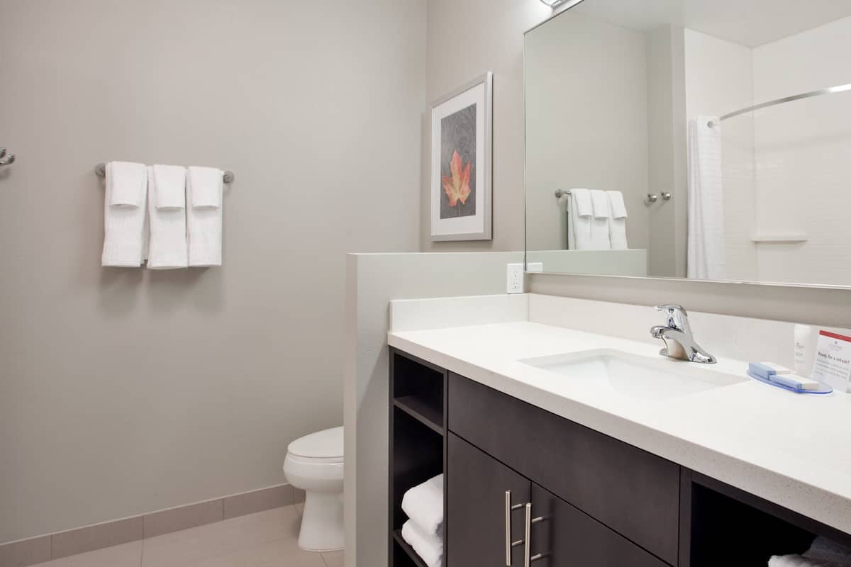Un baño moderno con un lavabo blanco, un espejo y un inodoro.