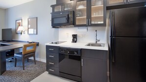 Una cocina moderna equipada con microondas, cafetera y refrigerador.