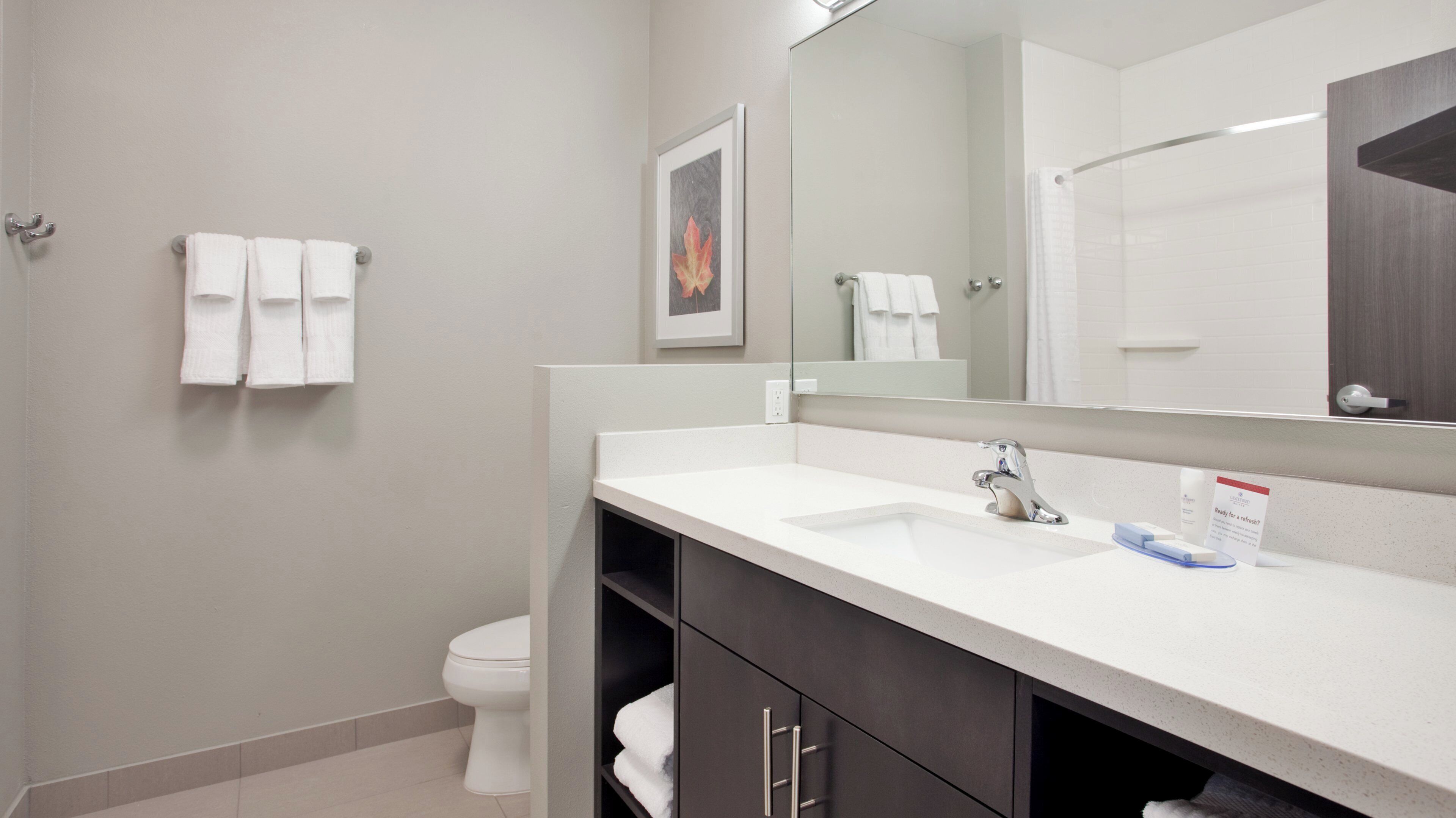 A modern bathroom with a white sink, a mirror, and a toilet.