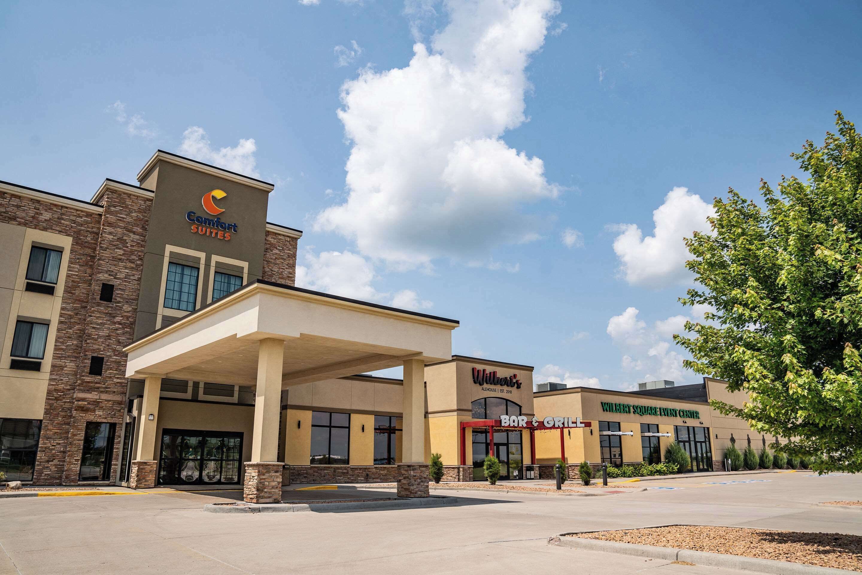 Un hotel con el letrero Comfort Suites, Willard Square Entry Center y un bar y parrilla.