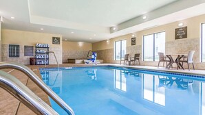Une piscine équipée d’un élévateur pour faciliter l’accès, d’un espace de repos aménagé au bord de la piscine et d’un panneau indiquant qu’il est interdit de plonger.
