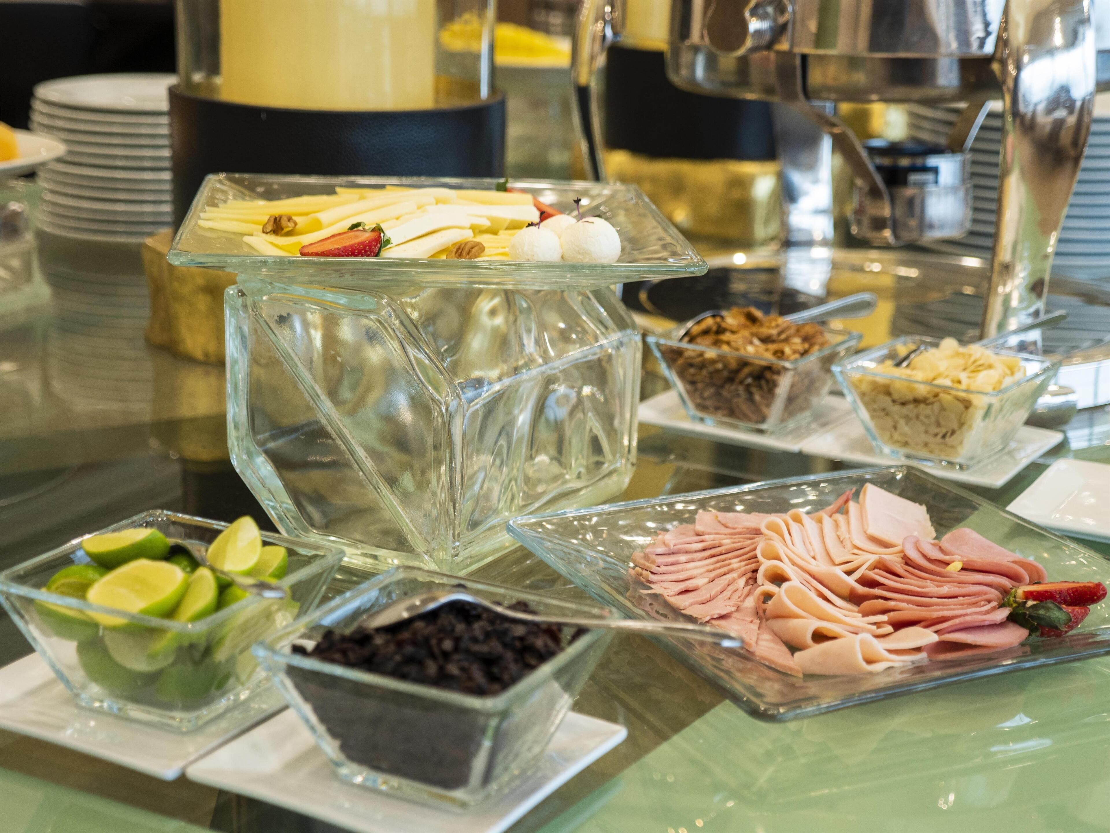 Een buffet met diverse soorten eten, waaronder gesneden fruit, noten en vlees.