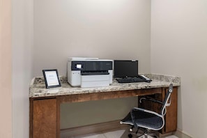 A small office space with a desktop computer, a printer, and a framed certificate on the counter. - Hyatt Select Valdosta (Valdosta)