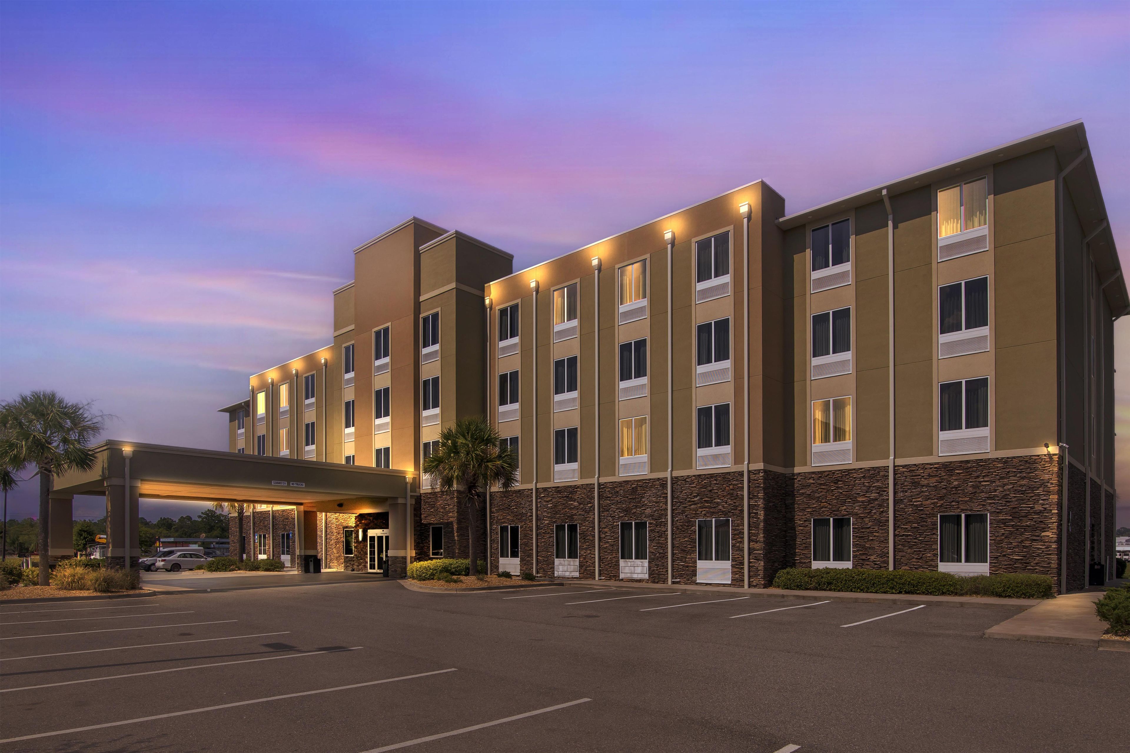 A multi-story hotel with a covered entrance and a parking lot.