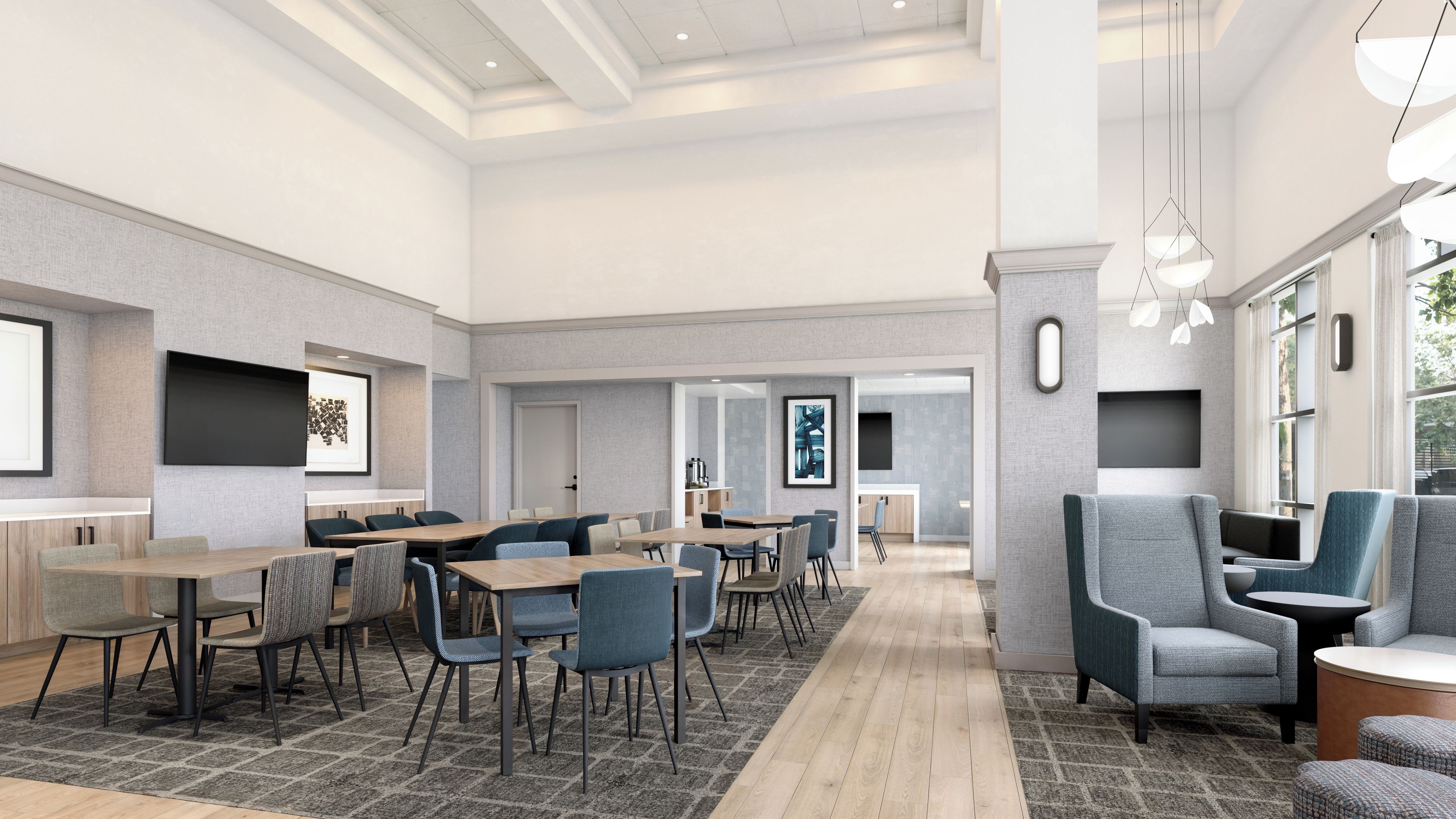 A modern hotel lobby with a long reception desk, seating area, and a view of the dining area.