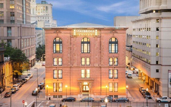 A Staybridge Suites hotel with a classic brick facade, large windows, and a prominent entrance.