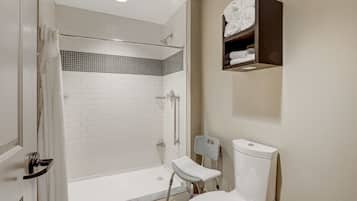 A modern bathroom with a walk-in shower, a toilet, and a towel rack.