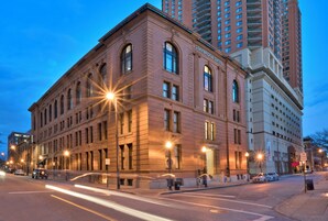 Un edificio histórico con una entrada arqueada destacada y un letrero que indica Staybridge Suites.