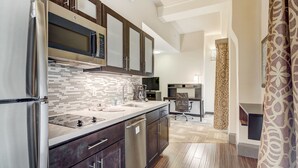 A modern kitchen with stainless steel appliances, dark wooden cabinets, and a tiled backsplash.