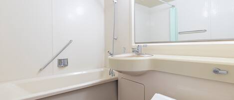 A modern bathroom with a white bathtub, a sink, and a toilet.