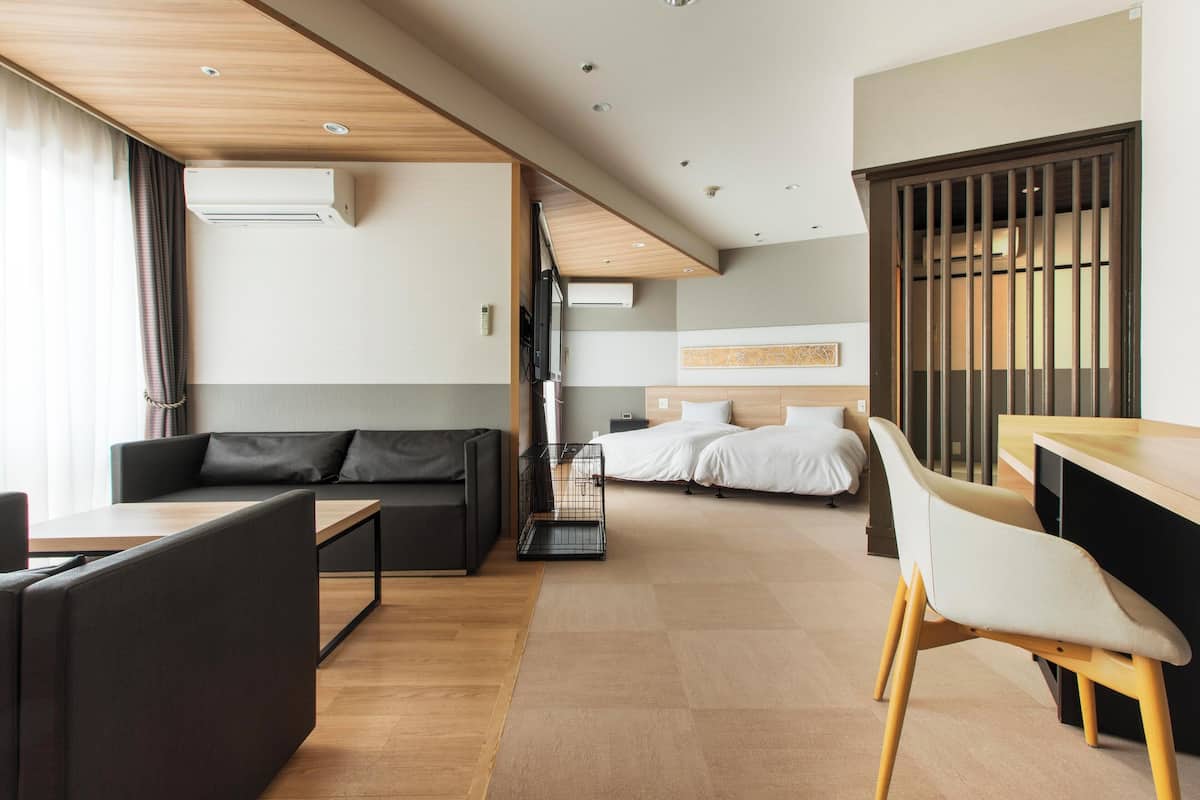 Een moderne hotelkamer met een bank, een eettafel, een bed en een televisie.