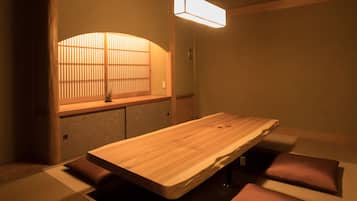 A traditional Japanese-style room with tatami flooring, a low wooden table, and a shoji screen.