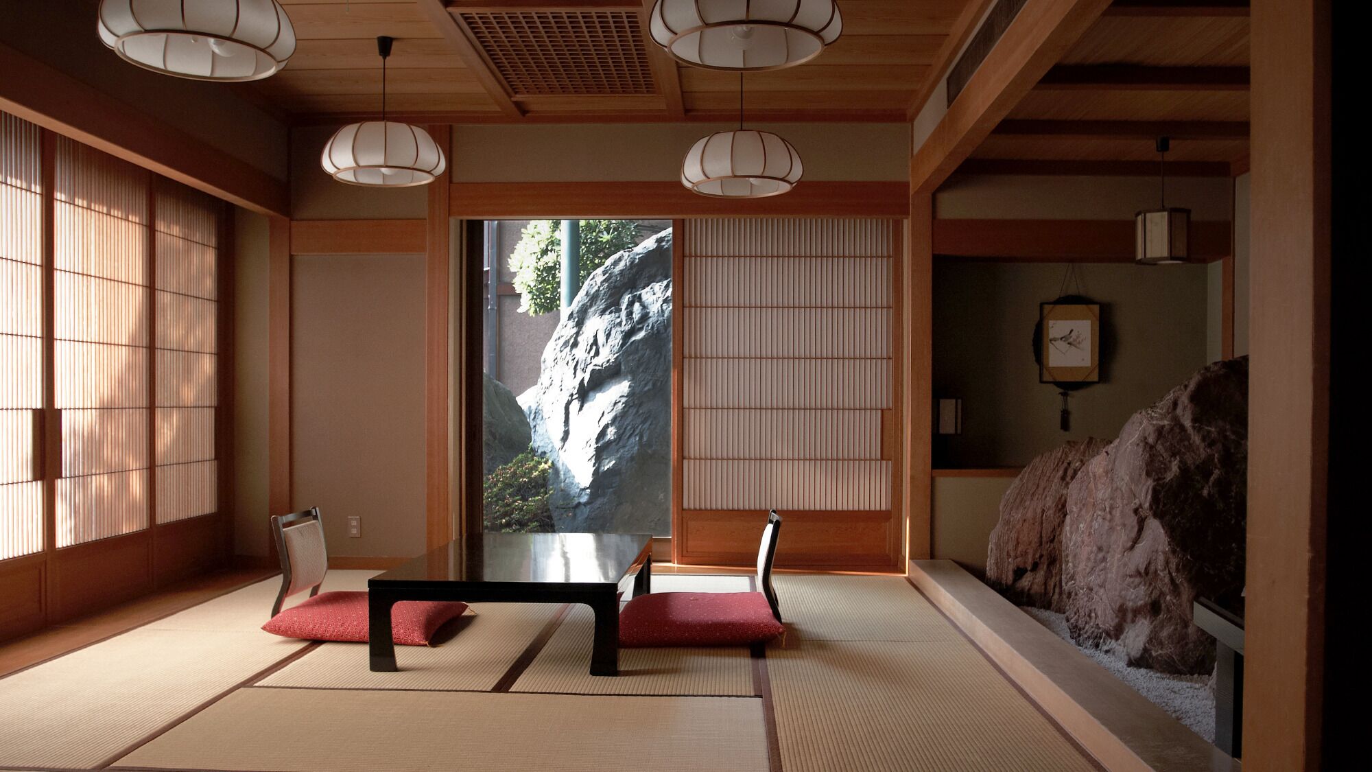 Ein traditioneller japanischer Raum mit Tatami-Böden, Shoji-Schirmen und einer Steingruppe.