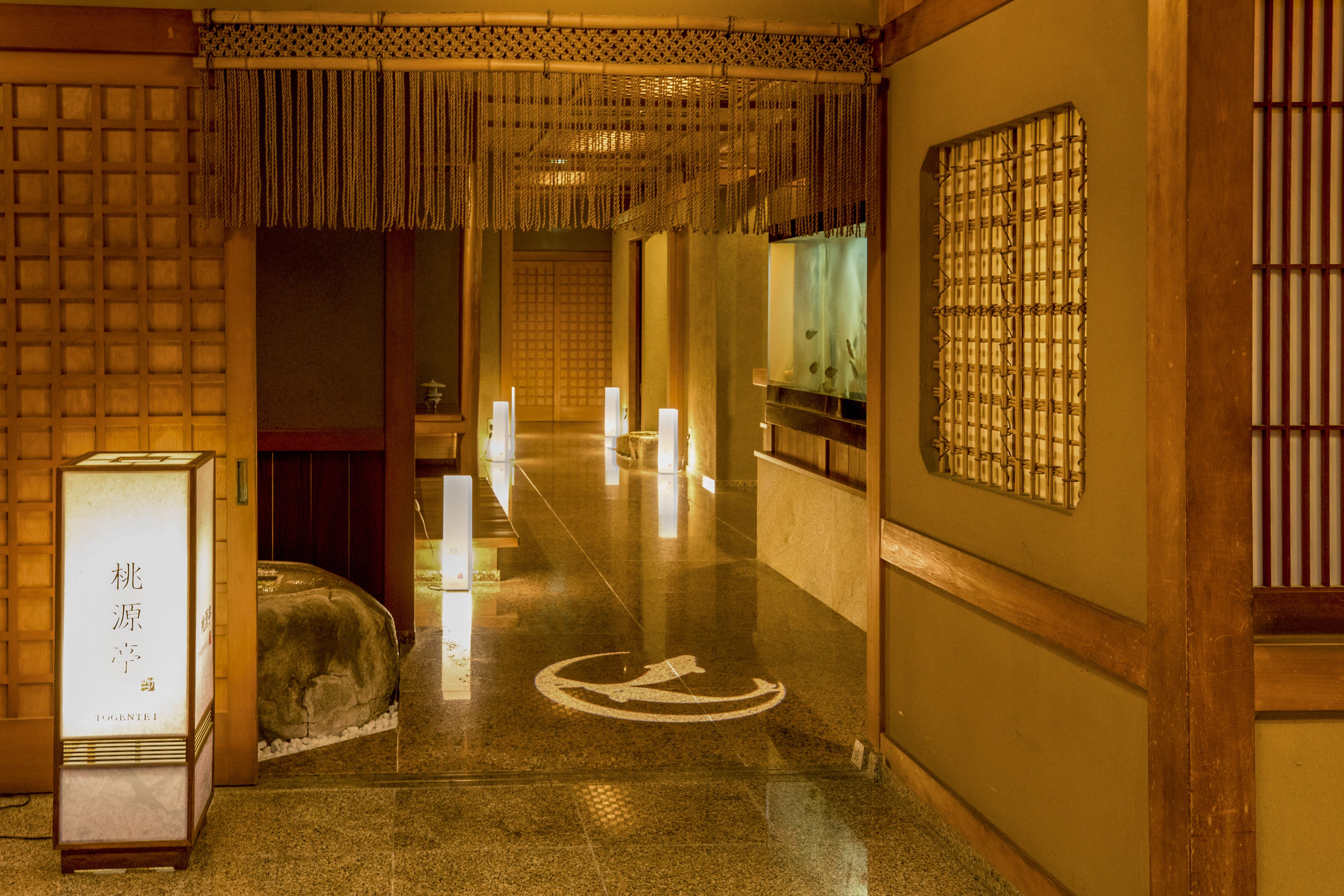 A traditional Japanese interior with tatami flooring, a reception desk, and a decorative screen.