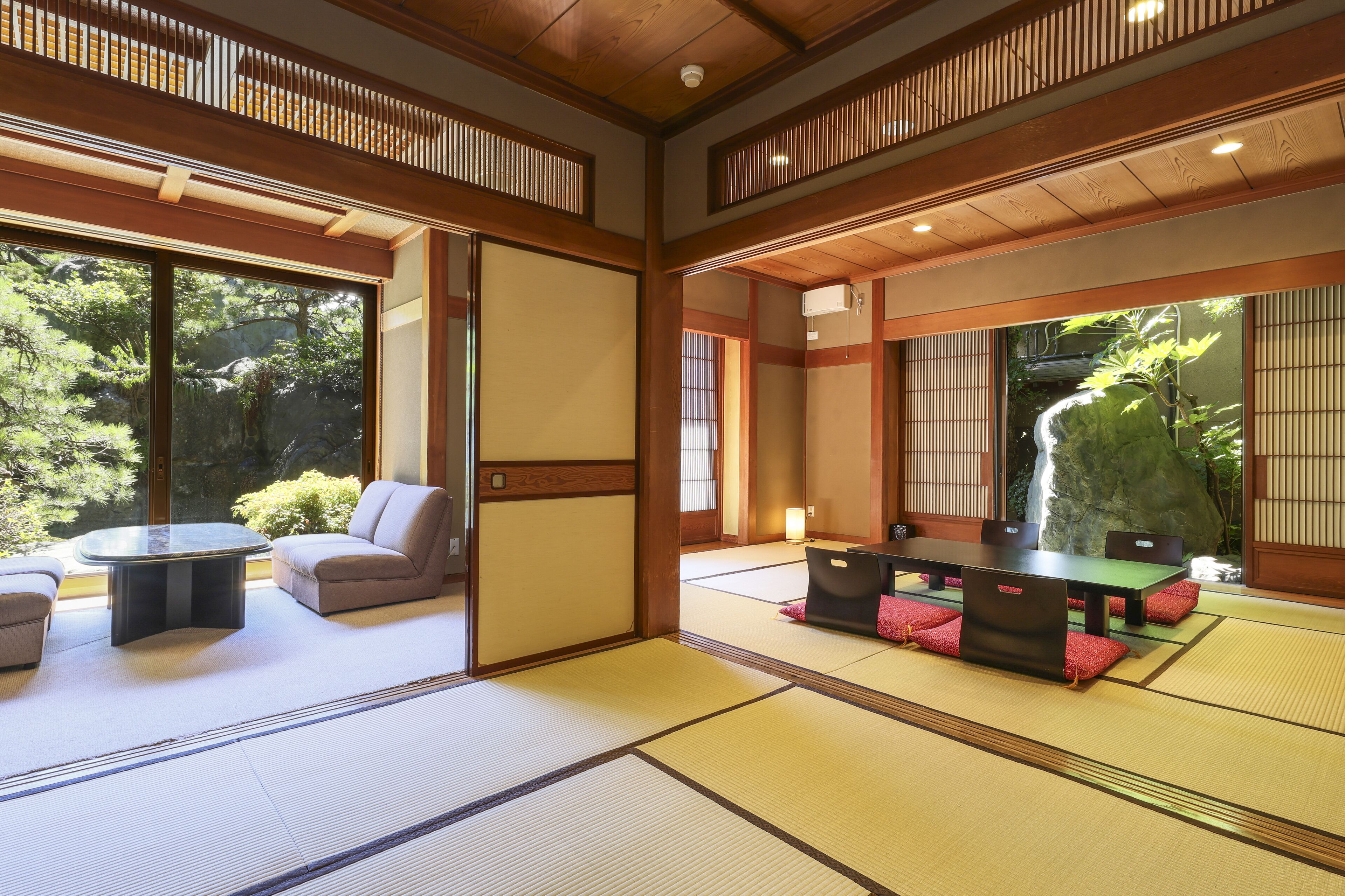 Una habitación japonesa tradicional con suelo de tatami, una mesa baja y asientos.